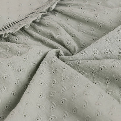 Textured fabric with floral embroidery pattern in shades of gray.