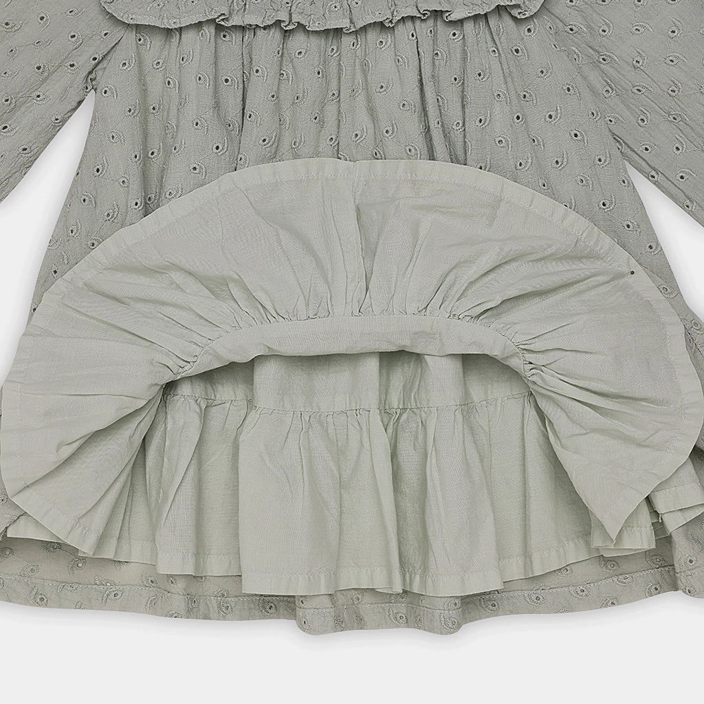 Close-up of a gray dress with ruffled details on a white background