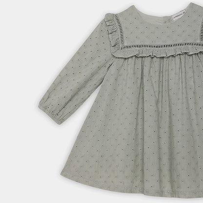 Green dress with ruffled neckline on a white background