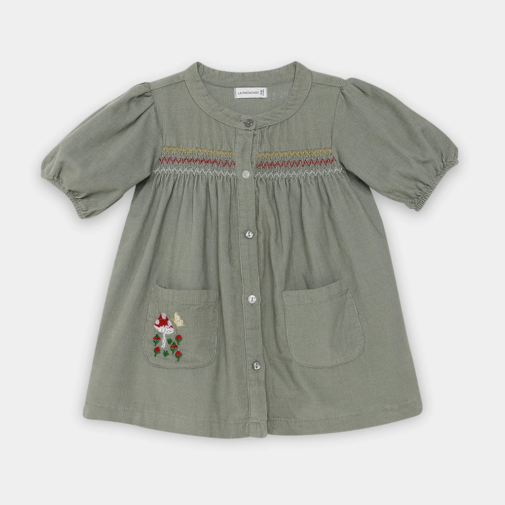 Green dress with embroidered details on a white background