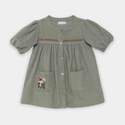 Green dress with embroidered details on a white background