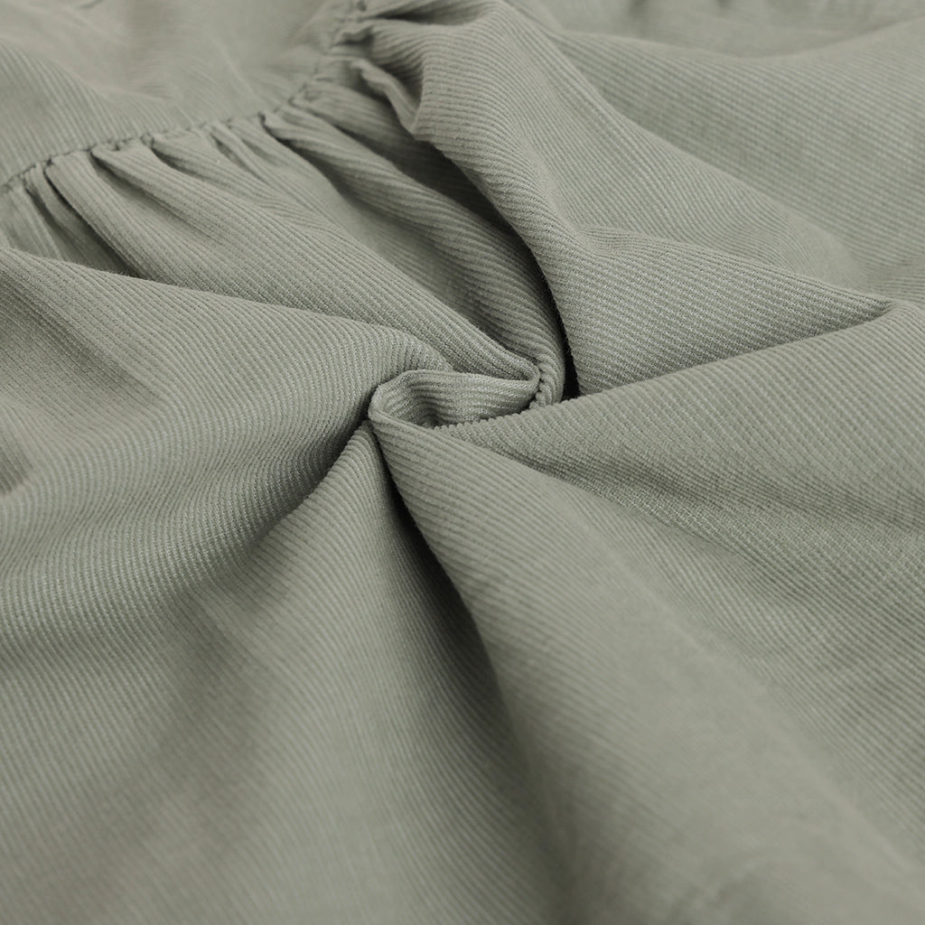 Close-up of textured green fabric with folds