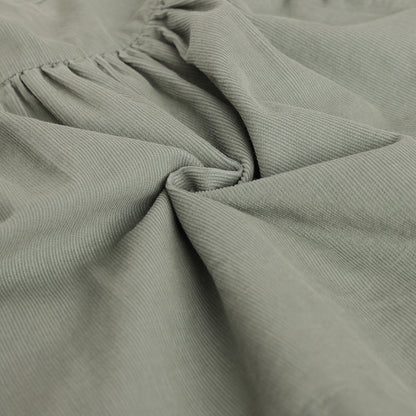Close-up of textured green fabric with folds