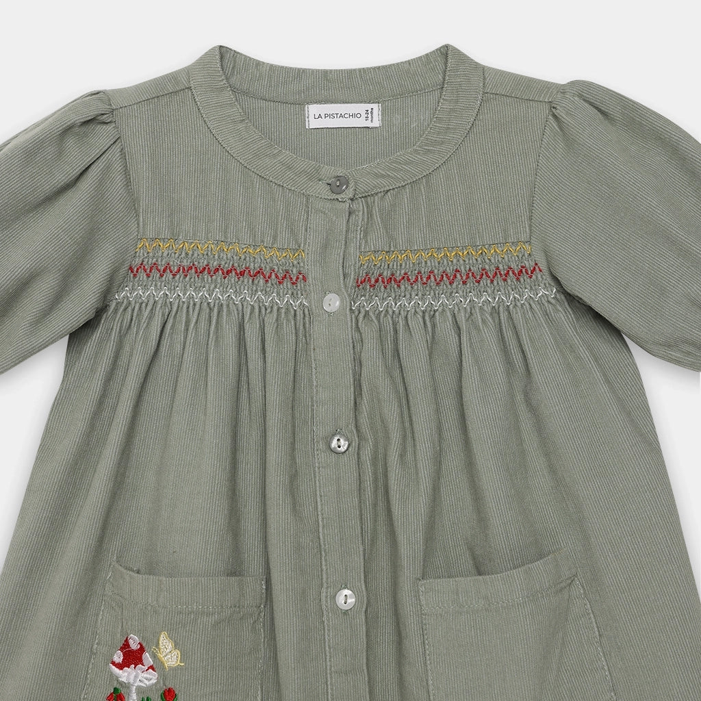 Green dress with embroidered details on a white background