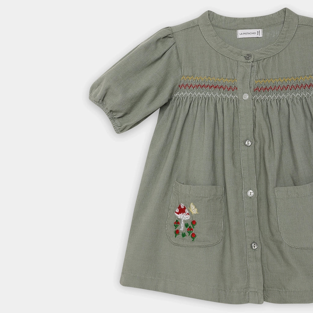 Green dress with floral pocket on a white background