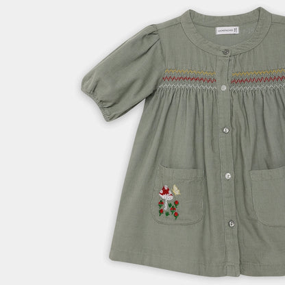 Green dress with floral pocket on a white background
