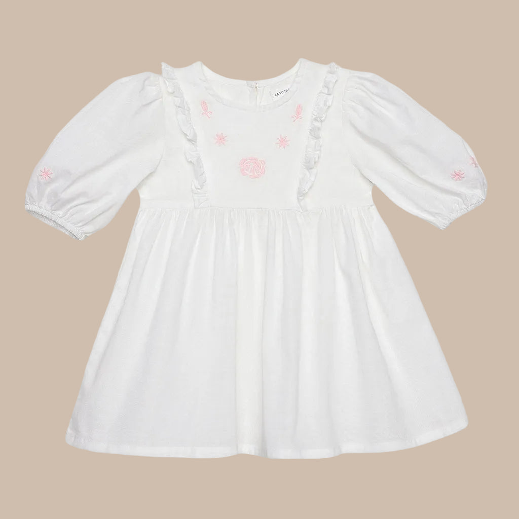 White dress with pink floral patterns on a light gray background