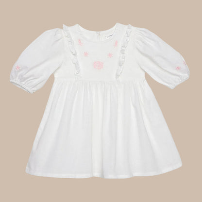 White dress with pink floral patterns on a light gray background