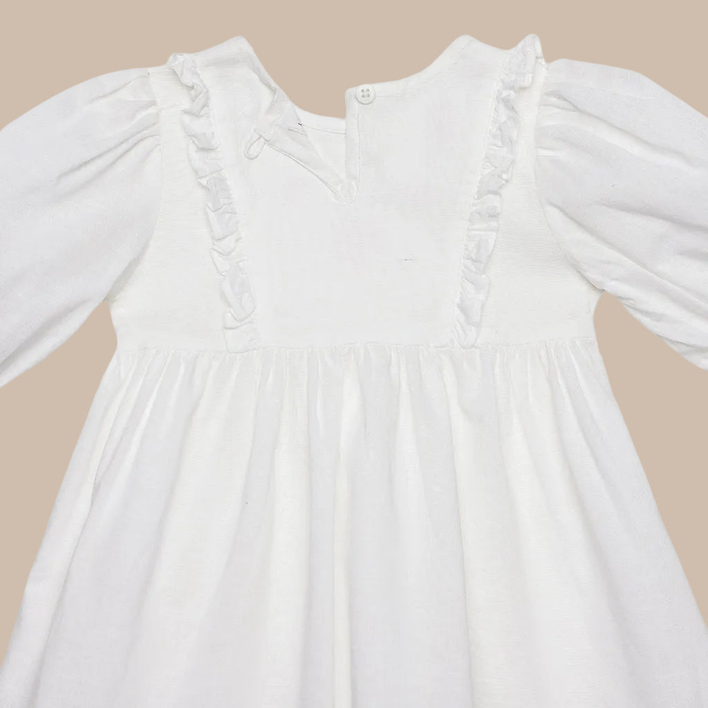 White dress with long sleeves and ruffled details on a white background