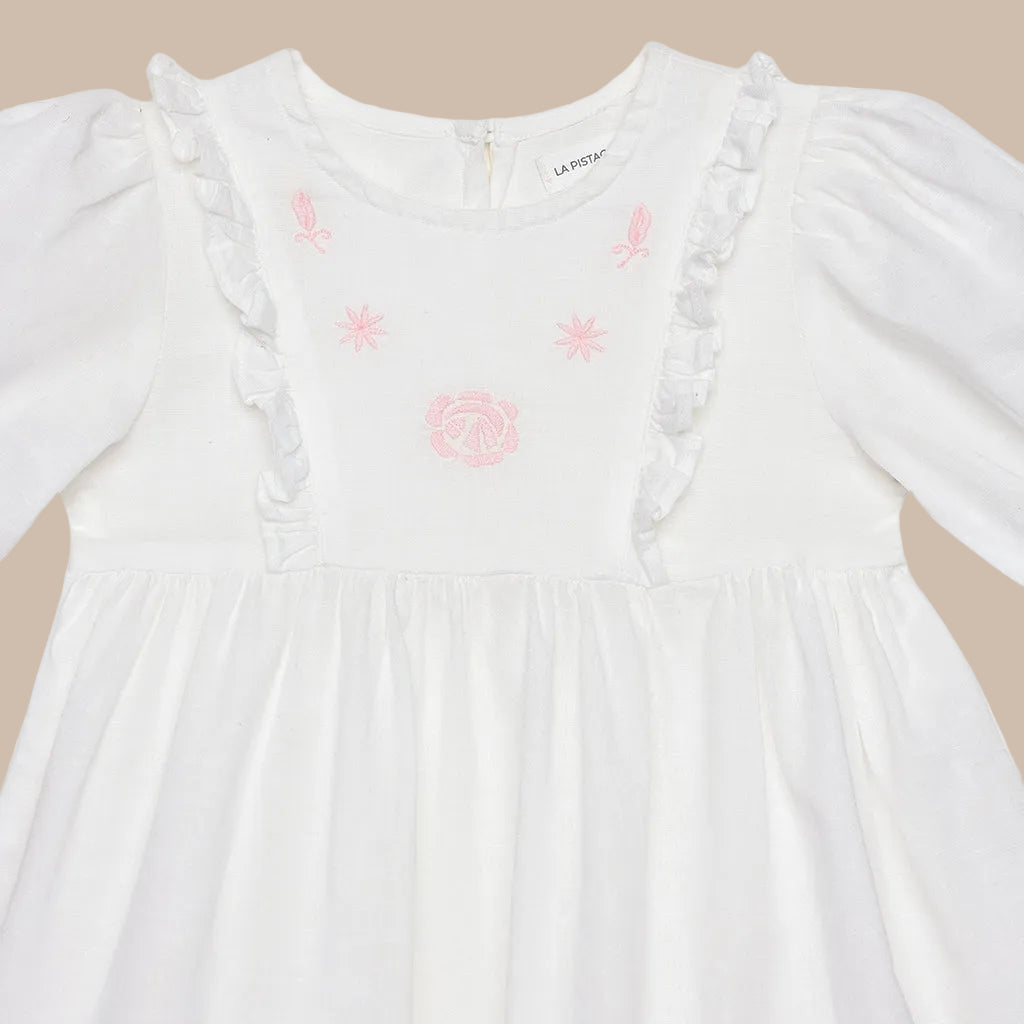 White dress with pink embroidery on a white background