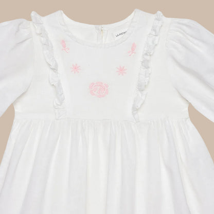White dress with pink embroidery on a white background