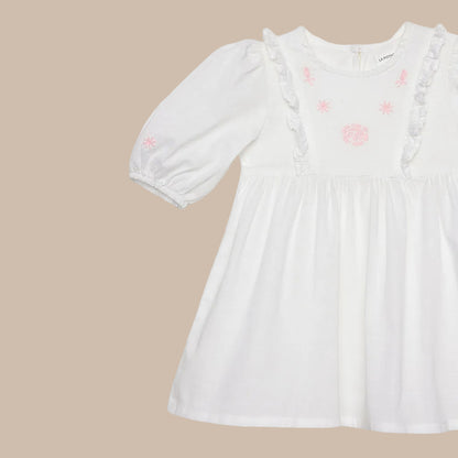 White dress with pink floral embroidery on a white background