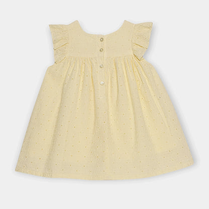 Yellow dress with a subtle pattern on a light gray background