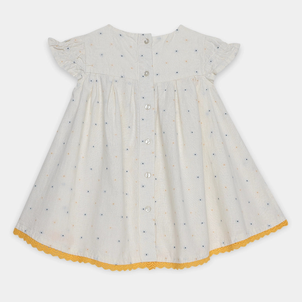 White dress with black polka dots and yellow trim on a white background