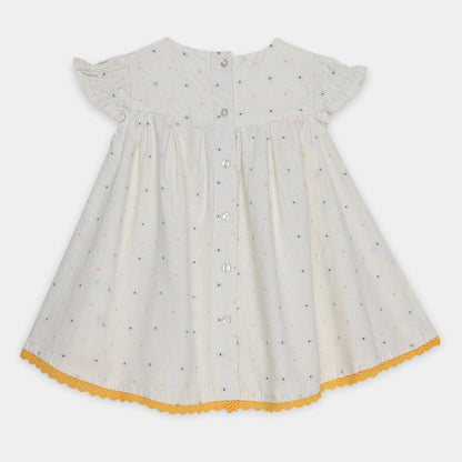 White dress with black polka dots and yellow trim on a white background