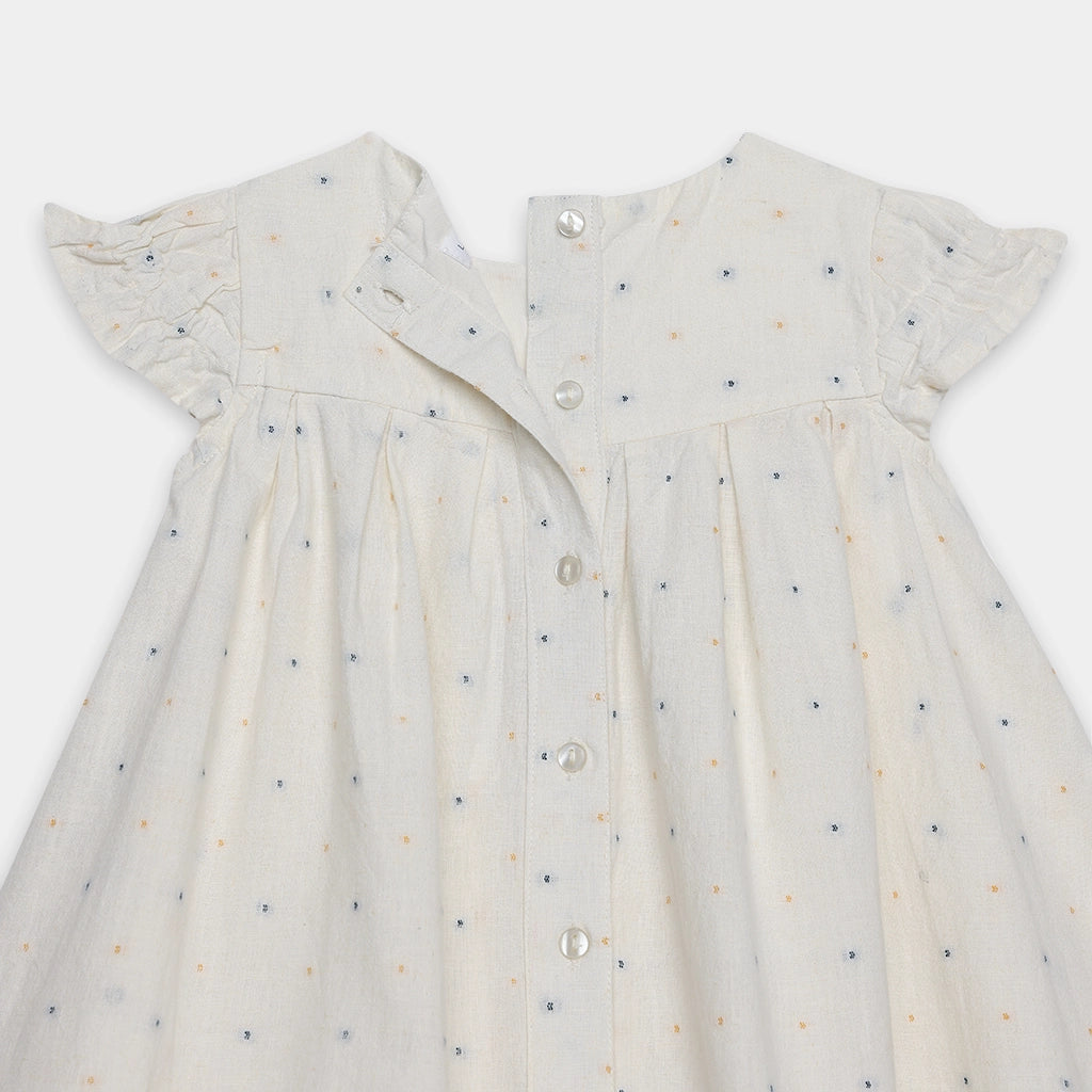 White dress with small blue and orange patterns on a white background