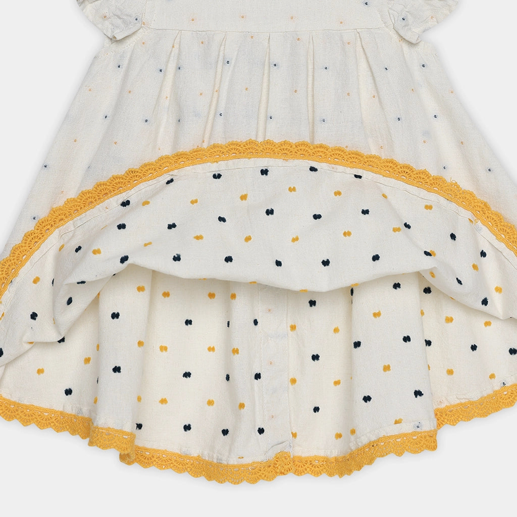 Close-up of a dress with polka dot pattern and yellow trim on a white background