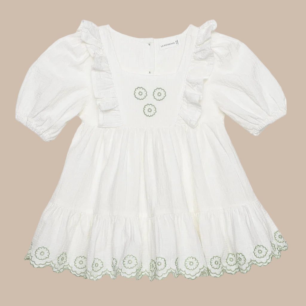 White dress with floral lace details on a white background