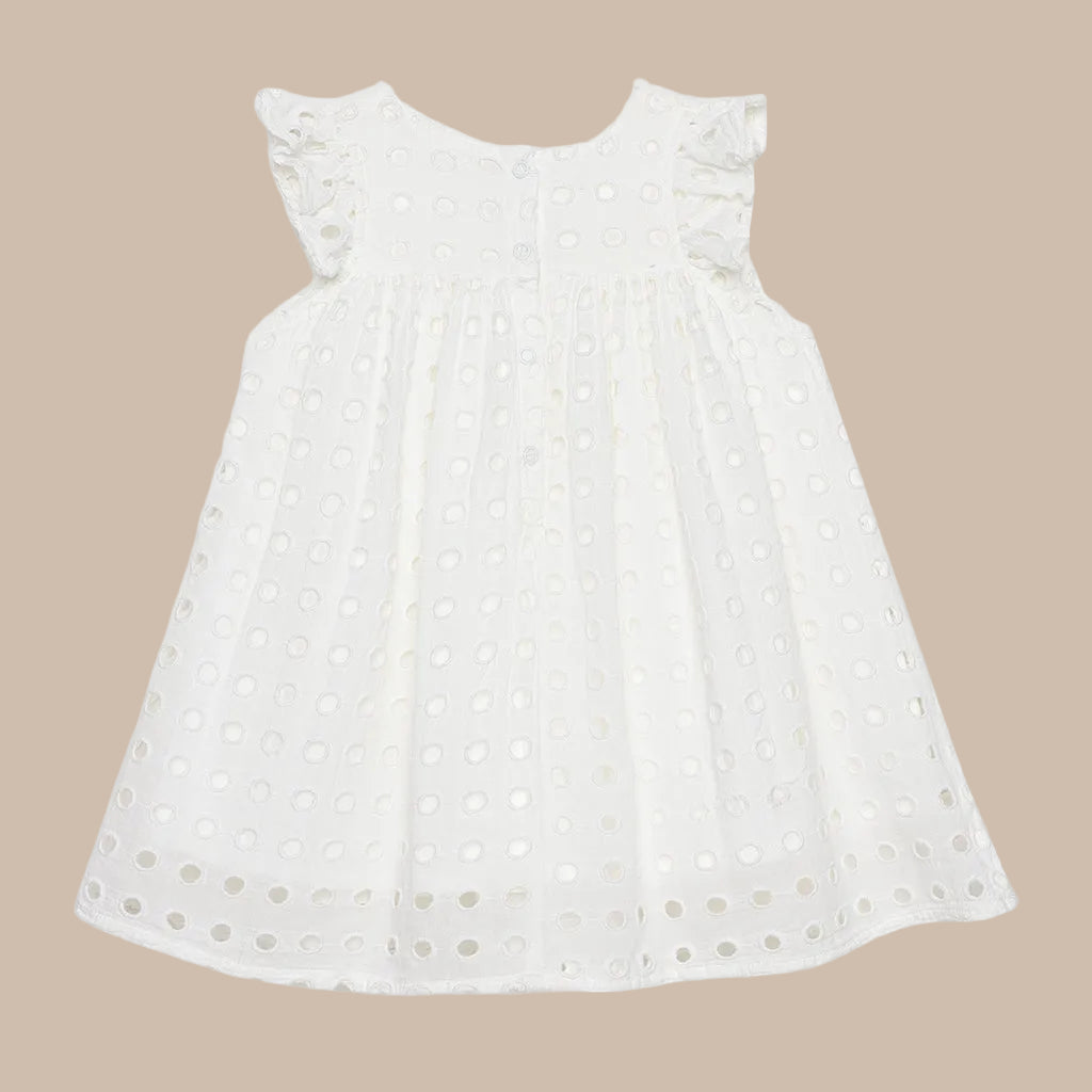 White dress with small black polka dots on a light gray background
