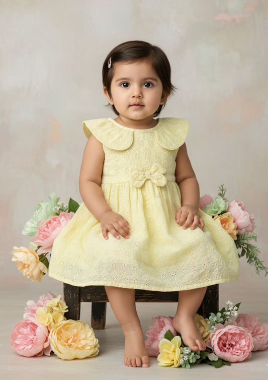 Baby girl sitting on stool wearing buttercup hakoba cotton frock