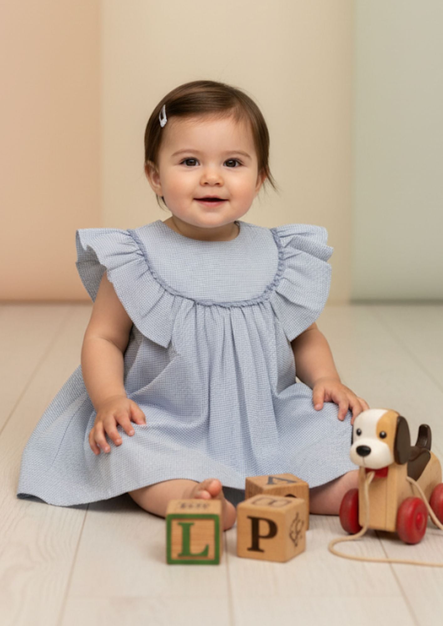 Baby girl sitting wearing sky blue seersucker cotton A-line dress