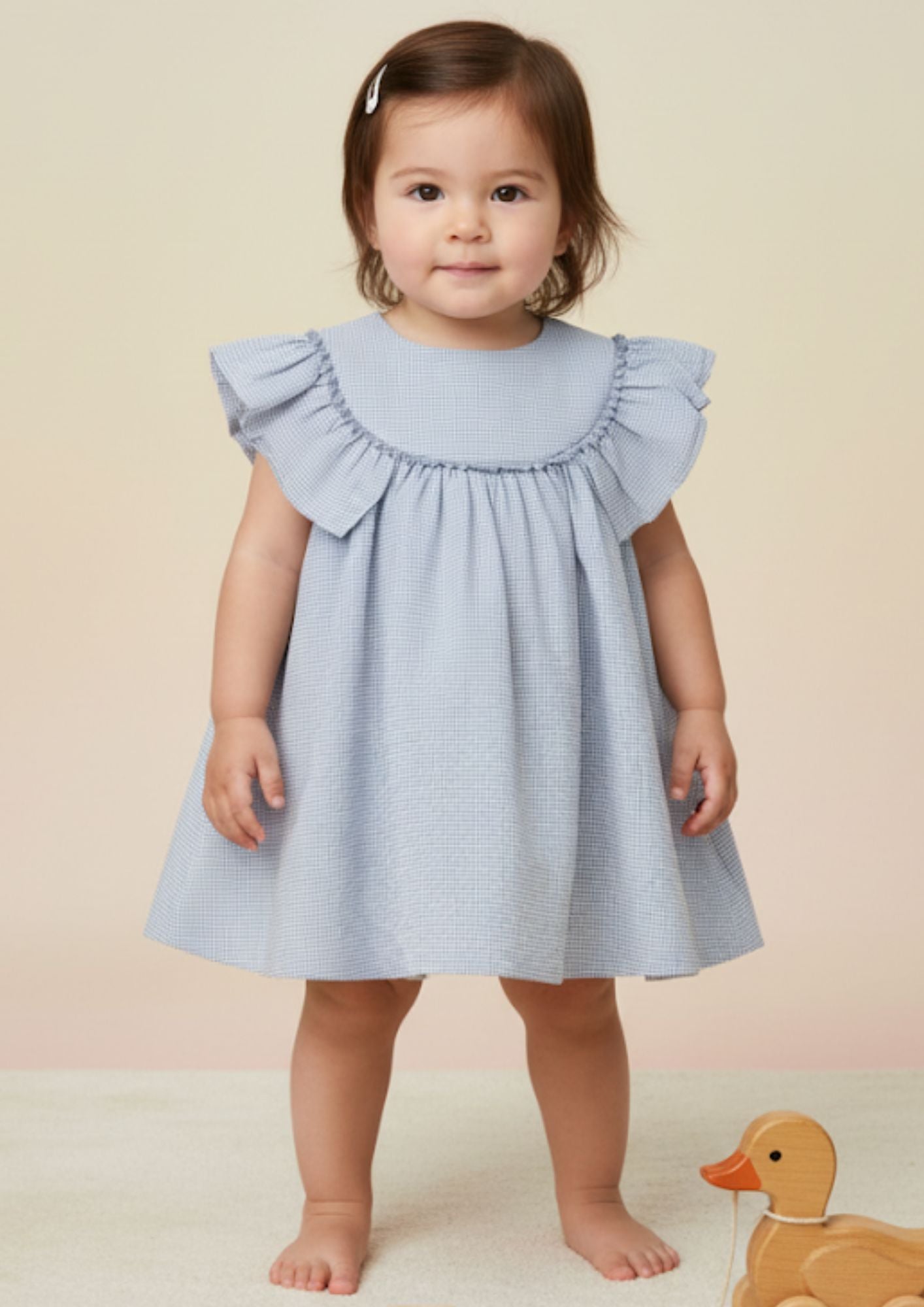 Baby girl standing wearing sky blue seersucker cotton A-line dress